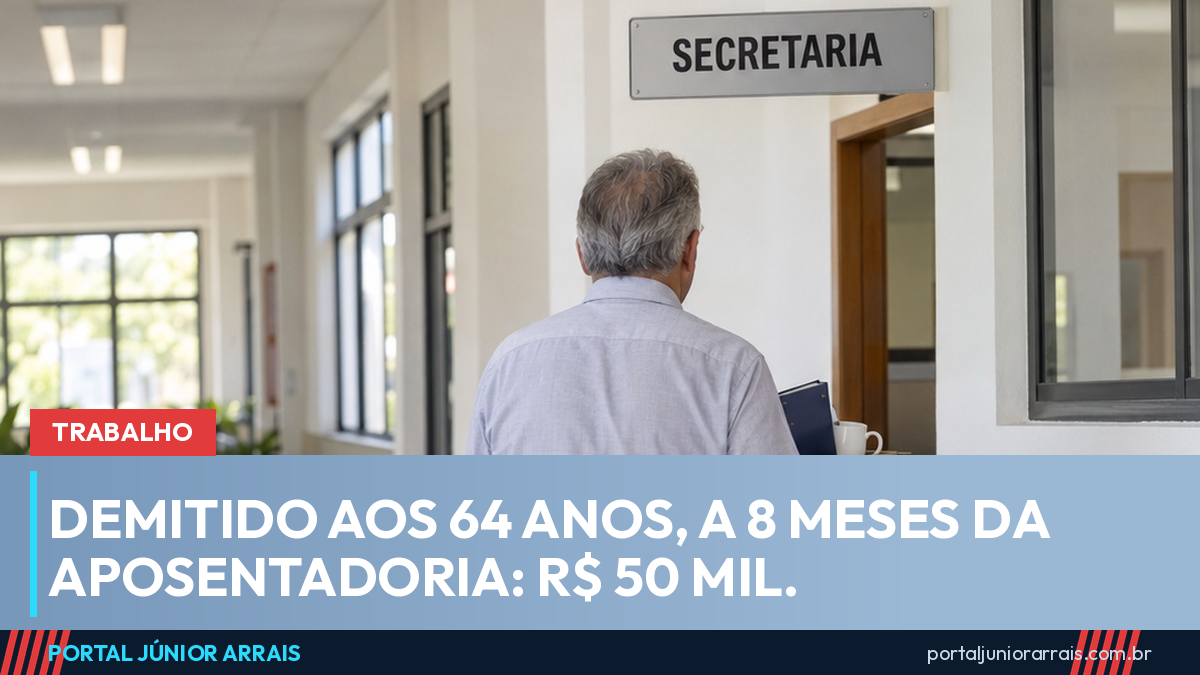 Homem grisalho visto de costas carregando uma caixa de papelão por um corredor de escola, sob uma placa escrita SECRETARIA